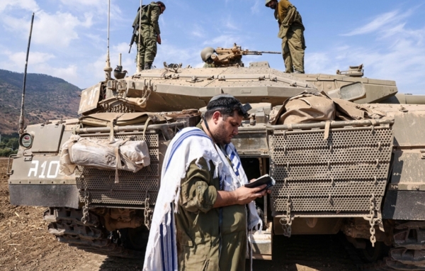 이스라엘 군인이 2023년 10월 8일 레바논 국경 근처 북부 마을 키르야트 시모나 외곽의 메르카바 탱크 앞에 서서 기도하고 있다.    게티 이미지