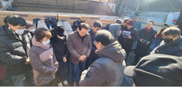 ‘선한청지기’ 관계자들이 구룡마을 이재민들을 위로하며 기도하고 있다.    ©선한청지기